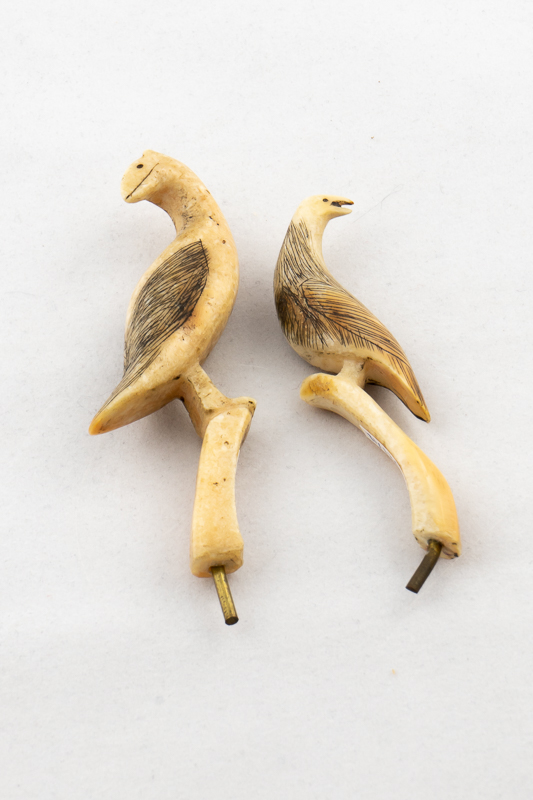 Two birds carved in ivory with fine feather incised on their backs.